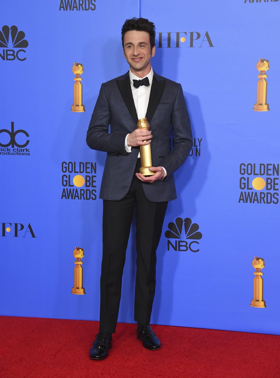 Justin Hurwitz posing with his Golden Globe