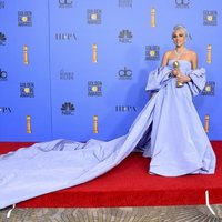 Lady Gaga posing with the Golden Globe for Best Original Song