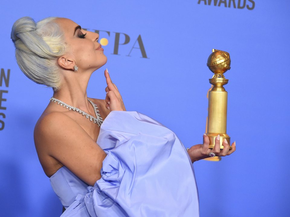 Lady Gaga poses with a Golden Globe