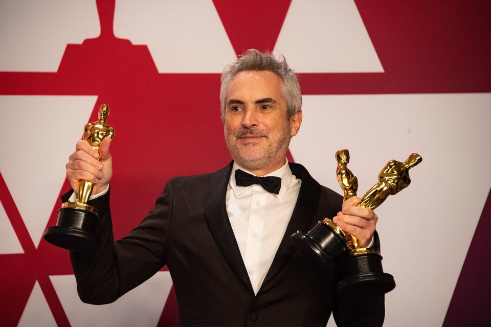 Alfonso Cuarón poses with his three Oscars