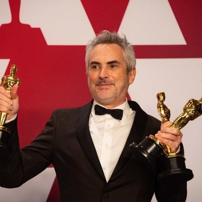 Alfonso Cuarón poses with his three Oscars