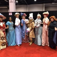 Fans dressed up as Victorian Disney princesses with Lumiere