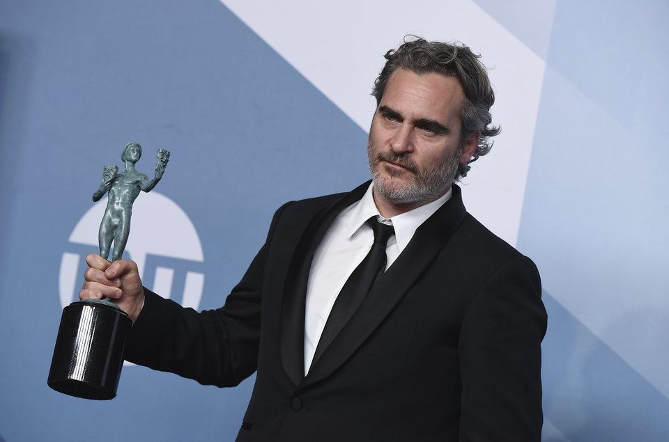 Joaquin Phoenix poses with his award on the carpet of the SAG Awards 2020