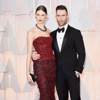 Adam Levine pose with his spouse Behati Prinsloo at the red carpet of the Oscar 2015