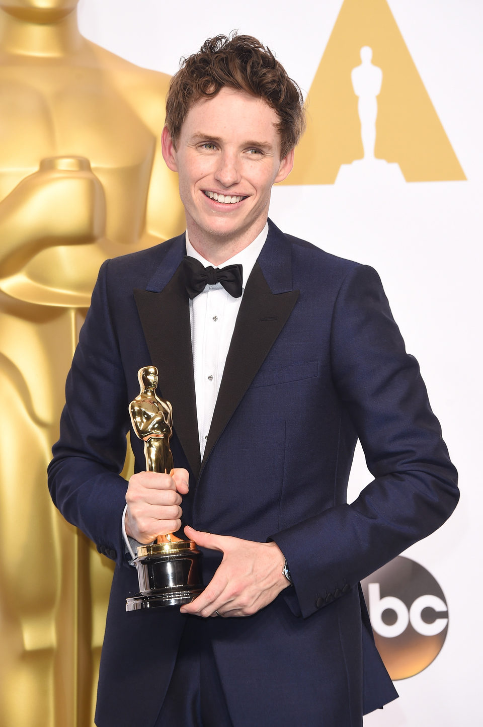 Eddie Redmayne poses with his first Oscar for the Best actor