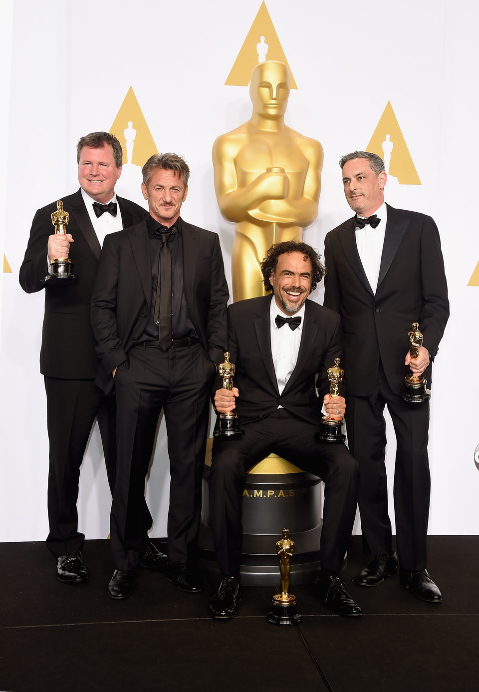 Alejandro González Iñárritu poses next to his three Oscars and Sean Penn