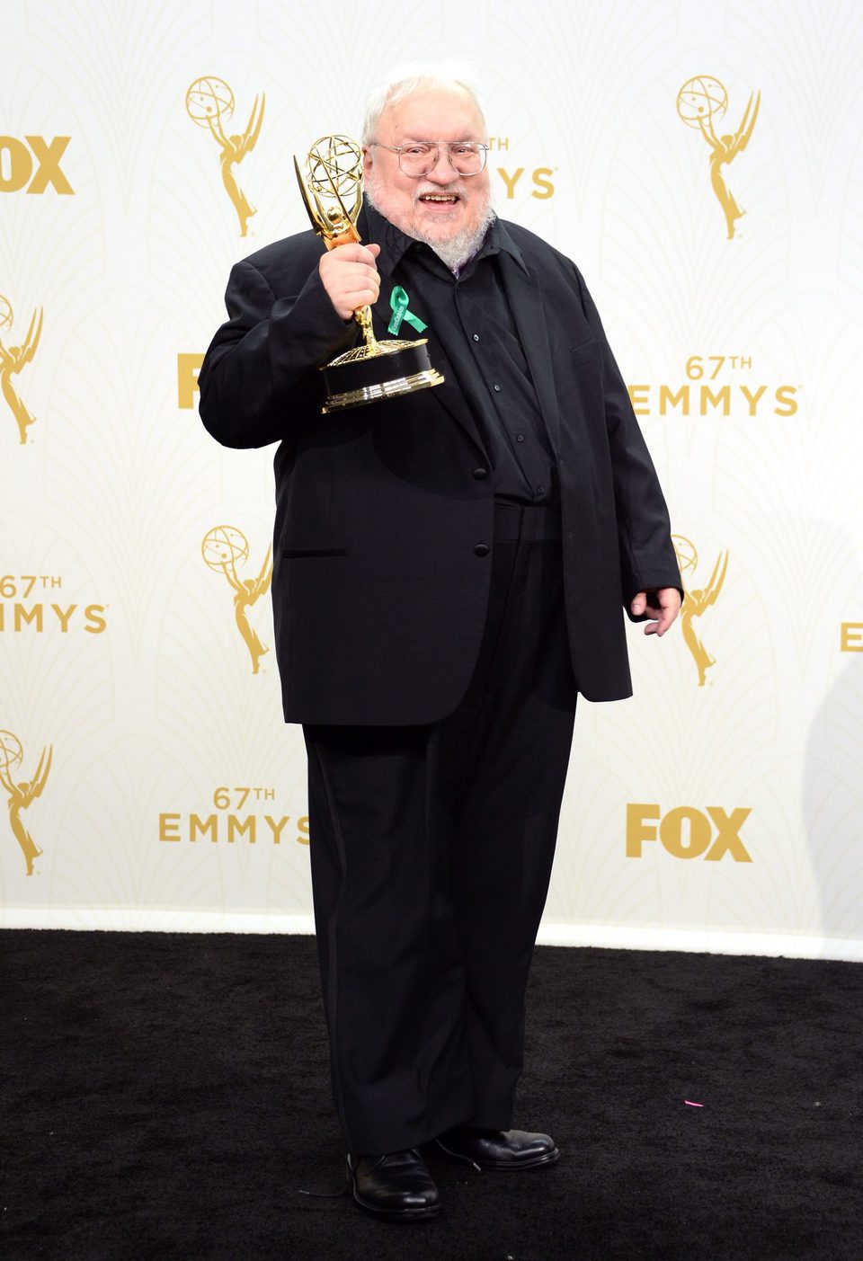 George R.R. Martin posing with his 2015 Emmy Award