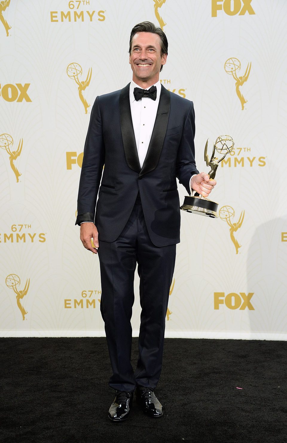 Jon Hamm posing with his 2015 Emmy Award