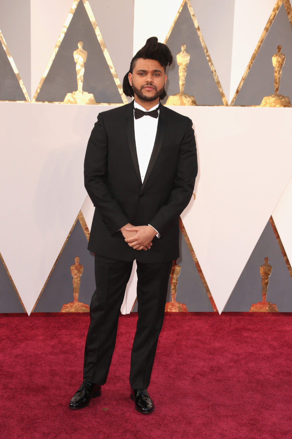 The Weeknd poses at the Oscars 2016 red carpet