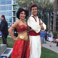 Two fans dressed up like Jasmine and Aladdin