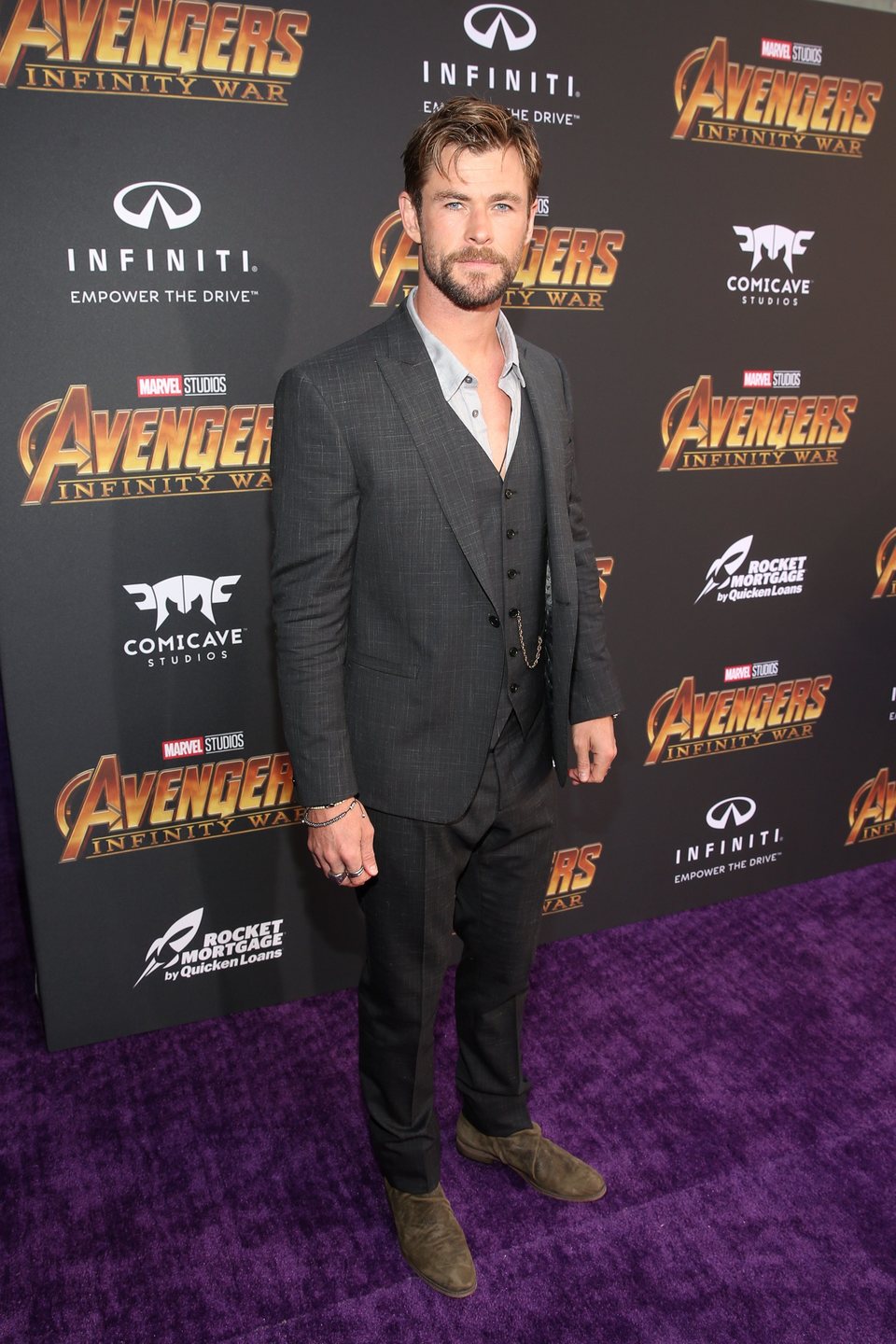 Chris Hemsworth poses on the purple carpet at the world premiere of 'Avengers: Infinity War'